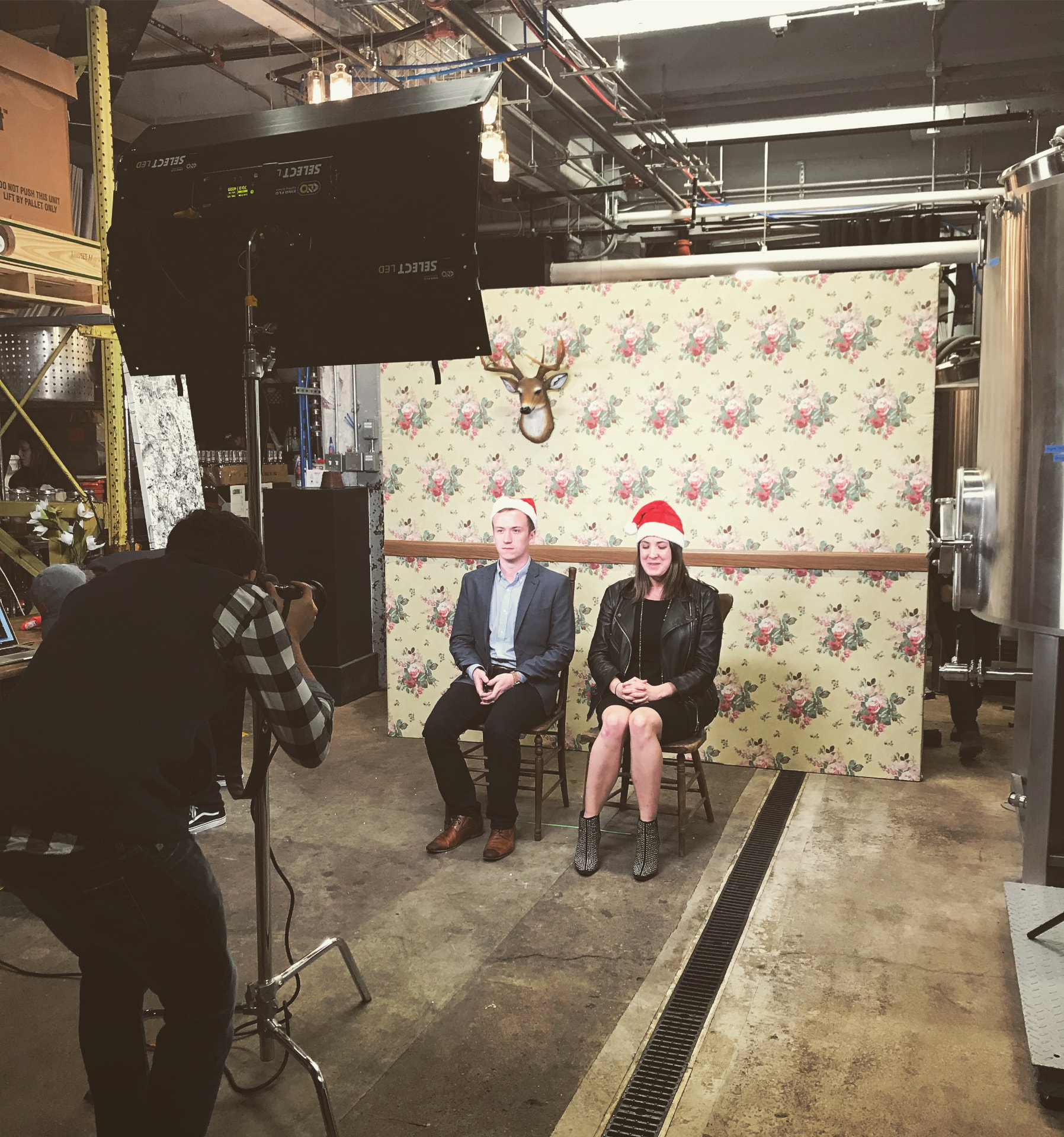 Guests posing in Santa hats at the vintage photo moment during the Curated Buy pop-up